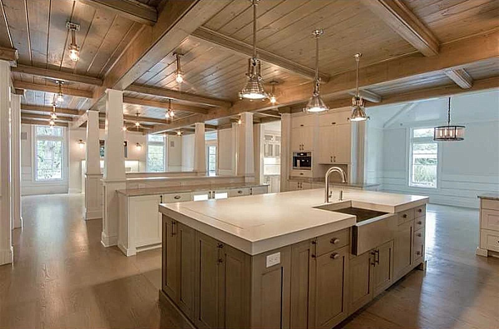 Concrete kitchen island under a wood beam ceiling